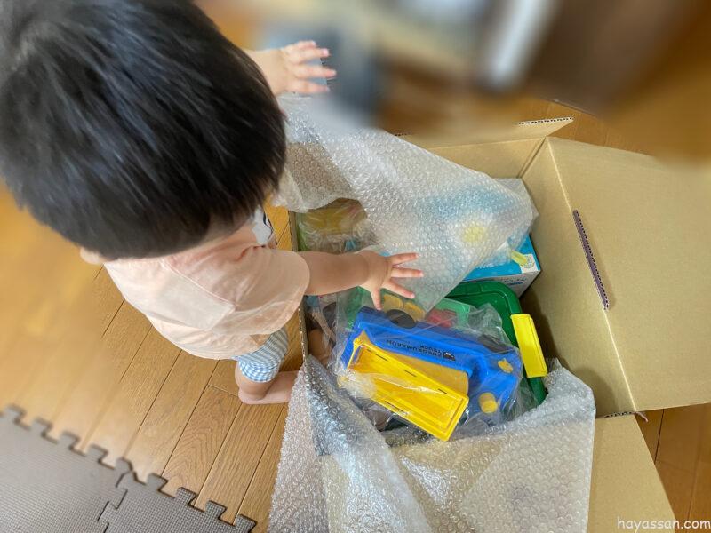 おもちゃのサブスクで、ダンボールからおもちゃを取り出している